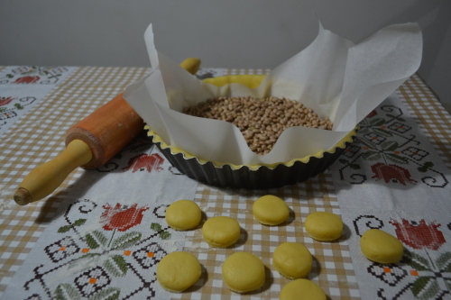 Truque: bote feijões em cima de papel manteiga sobre a massa, pra ela não inflar no forno